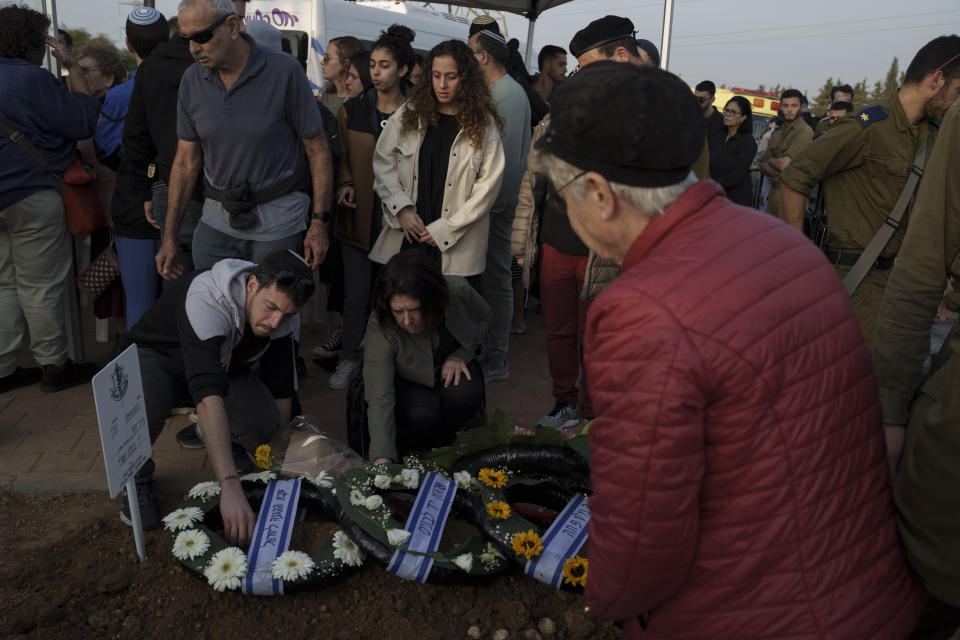 Relatives and friends mourn during the funeral of the Israeli Captain Neriya Zisk, at a cemetery in the village of Masu'ot Yitzhak, Israel, Thursday, Dec. 28, 2023. Zisk was killed in combat in the Gaza Strip. (AP Photo/Leo Correa)