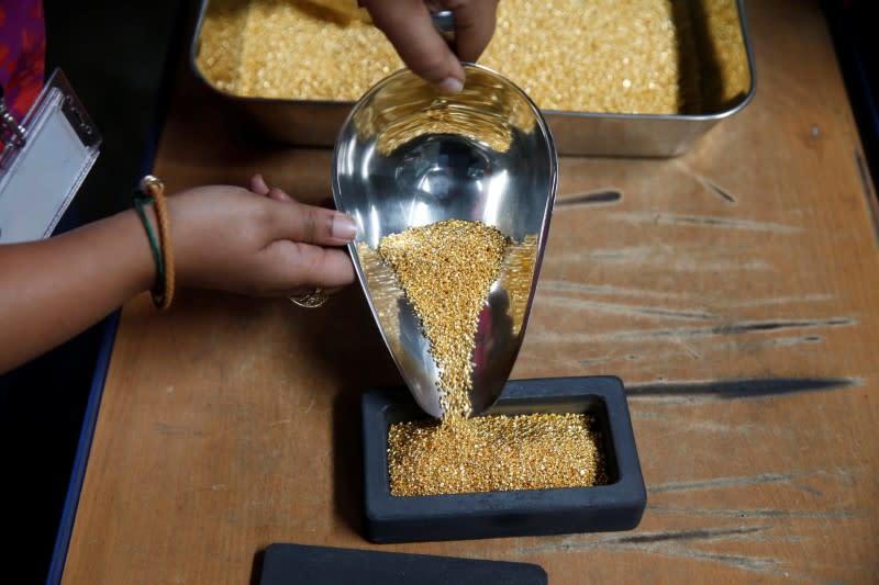 An employee pours gold grain to make a 1kg gold bar during a refining process at AGR (African Gold Refinery) in Entebbe