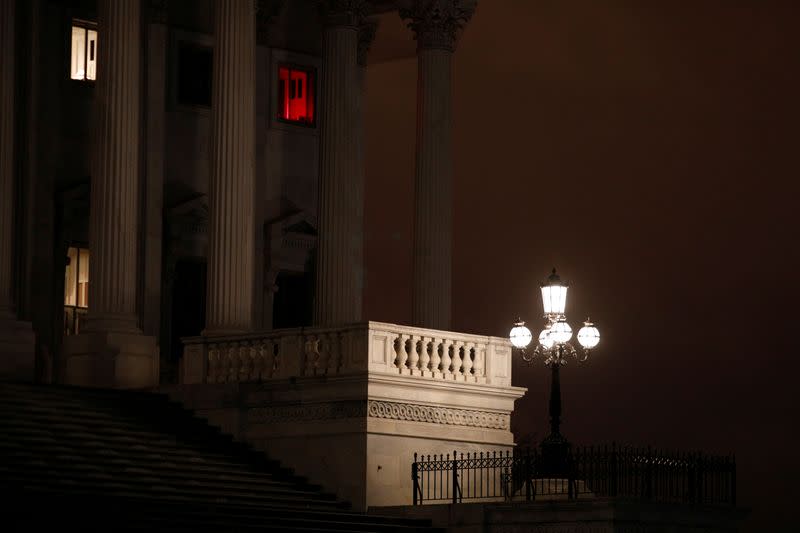 A window illuminated with a red light shines above the U.S. Senate steps, ahead of a vote on the coronavirus (COVID-19) relief bill on Capitol Hill in Washington