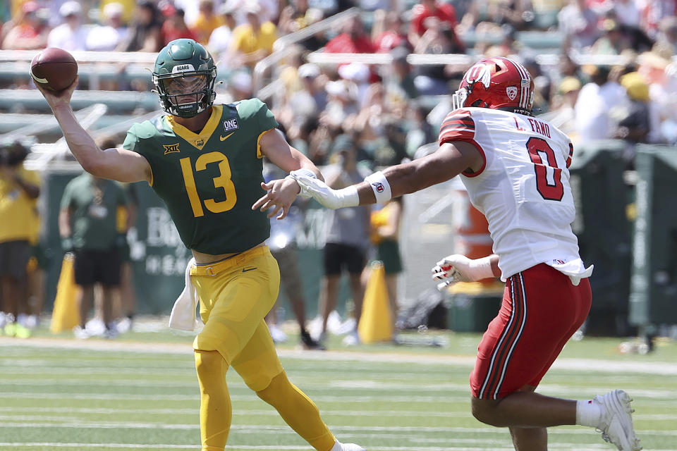 Baylor quarterback Sawyer Robertson throws on the run as Utah defensive end Logan Fano closes in the first half of an NCAA college football game, Saturday, Sept. 9, 2023, in Waco, Texas. (AP Photo/Jerry Larson)