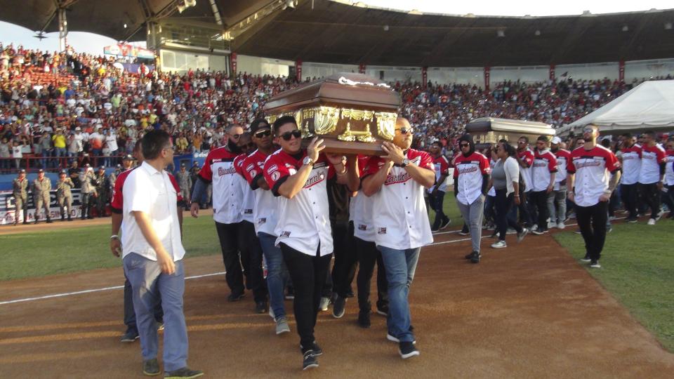 Players from the Cardenales de Lara baseball team carry the caskets of teammates and former major league players Luis Valbuena and Jose Castillo at a baseball stadium in Barquisimeto, Venezuela, Friday, Dec. 7, 2018. The two were killed in a car crash caused by highway bandits who then robbed them, officials said Friday. Valbuena and Castillo died late Thursday when their SUV crashed as it tried to veer around an object placed in the road, Yaracuy state Gov. Julio Leon Heredia said on his Twitter account. (AP Photo/Nestor Vivas)