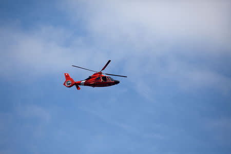 A U.S. Coast Guard helicopter flies overhead while the Shell Oil Company's drilling rig Polar Pioneer (unseen) enters waters in the Puget Sound near Seattle, Washington, May 14, 2015. REUTERS/Matt Mills McKnight