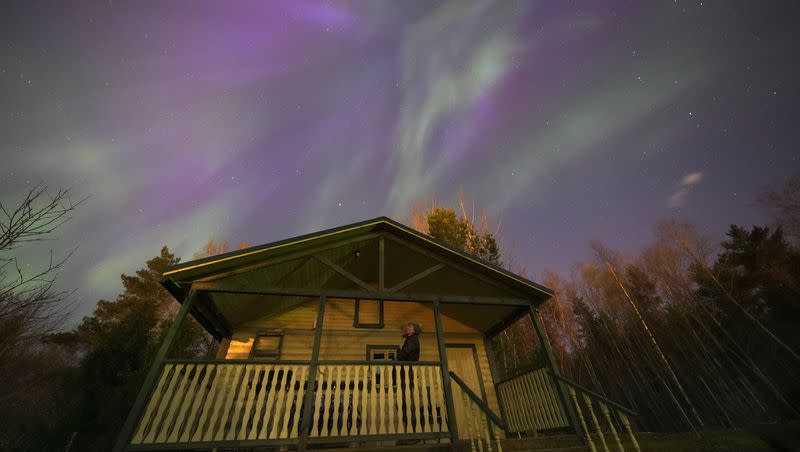 A woman watches northern lights (aurora borealis) over the village of Podolye, Russia, 70 kilometers (43 miles) east of St. Petersburg, on Sunday, April 23, 2023.