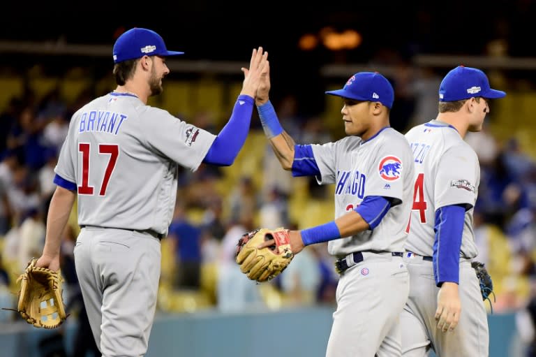 Kris Bryant (L) and Addison Russell of the Chicago Cubs celebrate their 10-2 victory against the Los Angeles Dodgers in game four of the National League Championship Series