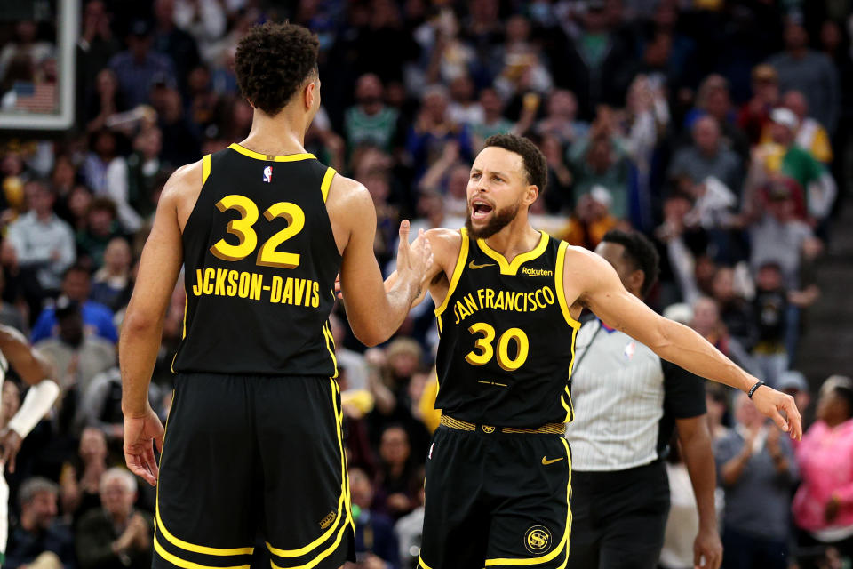 SAN FRANCISCO, CALIFORNIA - DECEMBER 19: Stephen Curry #30 high-fives Trayce Jackson-Davis #32 of the Golden State Warriors during their game against the Boston Celtics at Chase Center on December 19, 2023 in San Francisco, California. NOTE TO USER: User expressly acknowledges and agrees that, by downloading and or using this photograph, User is consenting to the terms and conditions of the Getty Images License Agreement.  (Photo by Ezra Shaw/Getty Images)