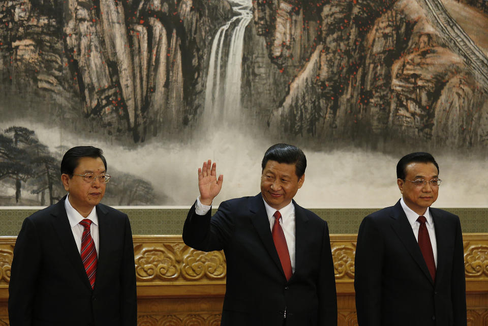 FILE - Communist Party General Secretary Xi Jinping, center, waves as he stands with new members of the Politburo Standing Committee Zhang Dejiang, left, and Li Keqiang in Beijing's Great Hall of the People on Nov. 15, 2012. When Xi Jinping came to power in 2012, it wasn't clear what kind of leader he would be. His low-key persona during a steady rise through the ranks of the Communist Party gave no hint that he would evolve into one of modern China's most dominant leaders, or that he would put the economically and militarily ascendant country on a collision course with the U.S.-led international order. (AP Photo/Vincent Yu, File)