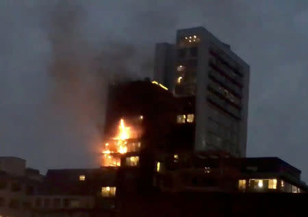 An apartment block on fire is seen in Manchester, Britain December 30, 2017 in this still image from a video obtained from social media. Rachel Fox/via REUTERS.