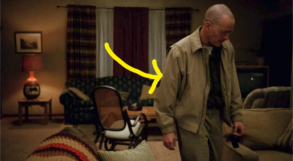Walt is wearing a tan collared jacket with a zipper