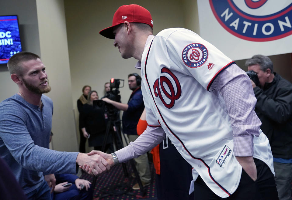 Washington Nationals pitcher Stephen Strasburg, left, shakes hands with new teammate Patrick Corbin during a baseball news conference at Nationals Park in Washington, Friday, Dec. 7, 2018. Corbin agreed to terms on a six-year contract and joins the Nationals after playing for the Arizona Diamondbacks. (AP Photo/Pablo Martinez Monsivais)