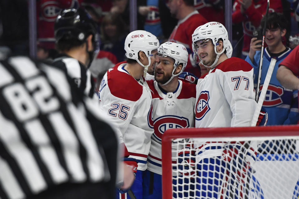 Montreal Canadiens right wing Denis Gurianov (25), left wing Jonathan Drouin (27) and center Kirby Dach (77) celebrate after defenseman Jordan Harris, behind right, scored against the Buffalo Sabres during the first period of an NHL hockey game in Buffalo, N.Y., Monday, March 27, 2023. (AP Photo/Adrian Kraus)