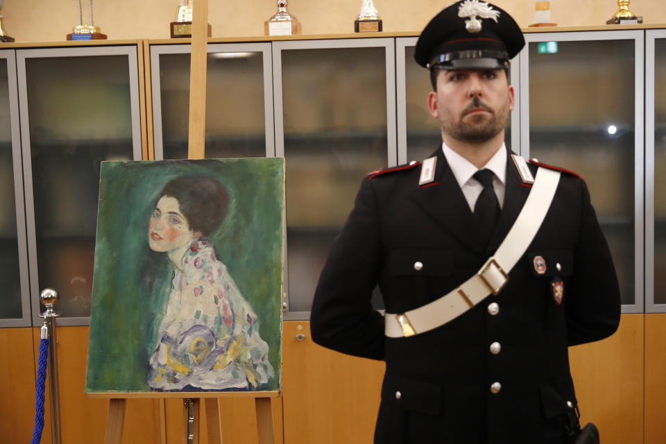 An Italian Carabiniere, paramilitary police officer, stands near a painting which was found last December near an art gallery and believed to be the missing Gustav Klimt's painting ‘Portrait of a Lady’ during a press conference in Piacenza, Italy, Friday, Jan. 17, 2020. Art experts have confirmed that a stolen painting discovered hidden inside an Italian art gallery's walls is Gustav Klimt's "Portrait of a Lady," Italian prosecutors said Friday. A gardener reported finding an art work inside a bag last month while clearing ivy at the Ricci Oddi Modern Art Gallery in the northern city of Piacenza. “Portrait of a Lady” disappeared from the gallery during renovation work in February 1997. (AP Photo/Antonio Calanni)