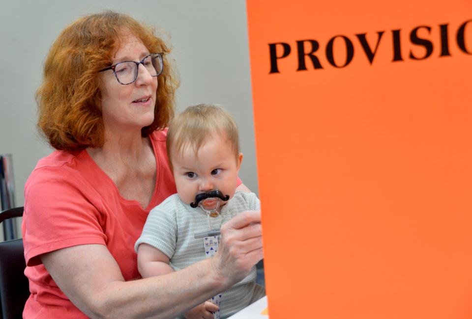 Karen Ecker, of the Hagerstown area, said Tuesday she wants her grandson, Teddy Tyler, 9 months, to learn how important it is to vote. Teddy, with his mustache pacifier, sits on his grandmother's lap while she starts to review her provisional ballot at the Washington County Board of Elections headquarters.