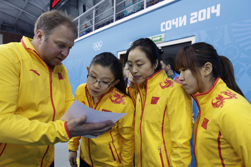 Team China coach Marcel Rocque, of Canada, talks with his players, from left, Wang Bingyu, Yue Qingshuang, and Jiang Yilun, after the first day of curling training at the 2014 Winter Olympics, Saturday, Feb. 8, 2014, in Sochi, Russia. (AP Photo/Robert F. Bukaty)