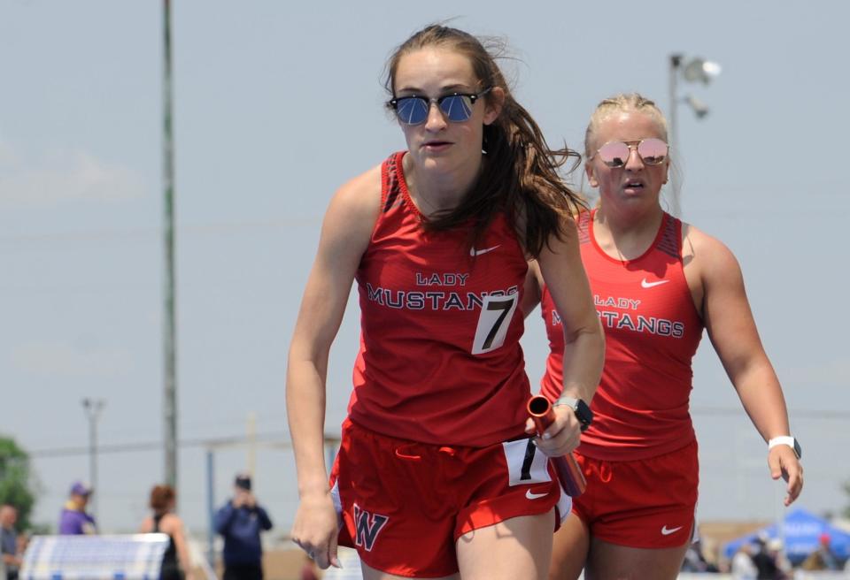 Westfall's Caitlyn Shipley takes the baton from teammate Summer Hanson during girls 4x400 relay in the Division II district track and field championships at Washington High School on May 20, 2023.