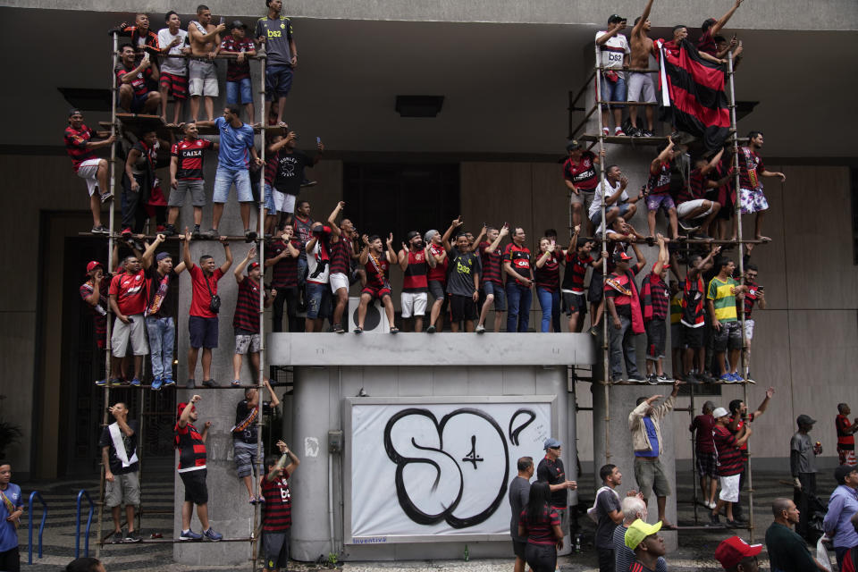 Fans of Brazil's Flamengo watch the team victory parade at their arrival in Rio de Janeiro, Brazil, Sunday, Nov. 24, 2019. Flamengo overcame Argentina's River Plate 2-1 in the Copa Libertadores final match on Saturday in Lima to win its second South American title. (AP Photo/Ricardo Borges)