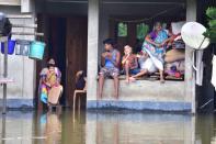 People inside their partially submerged house at flood affected at Baghmari village near Kaziranga in Nagaon District of Assam. (Photo credit should read Anuwar Ali Hazarika/Barcroft Media via Getty Images)