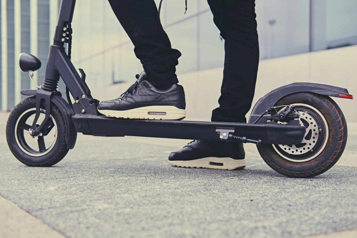 Close up image of a man on an electric scooter.