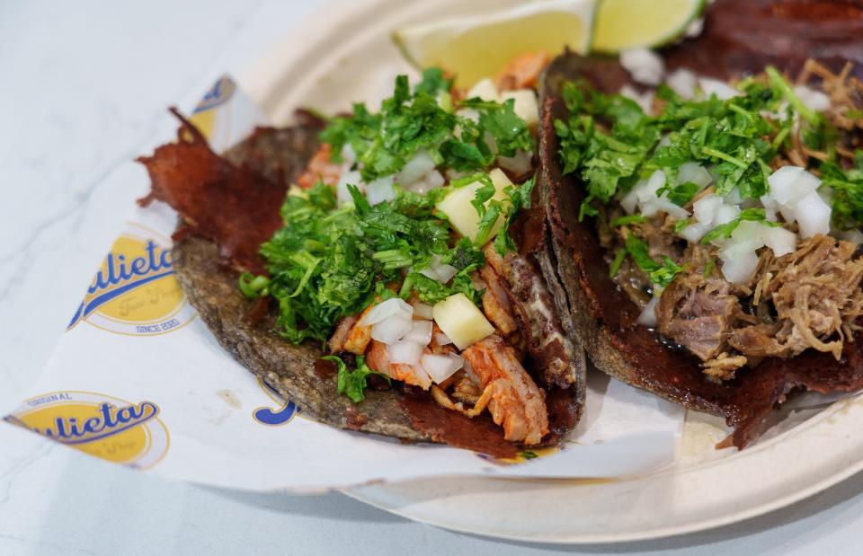 An al pastor and carnitas taco sit ready to eat Wednesday, Aug. 9, 2023, inside Taqueria de Julieta in The Stutz. "This is an Al Pastor taco," Esteban Rosas, a co-owner, said. "It's thinly sliced pork shoulder my dad shaves then we marinate in an adobo that Gabriel's mom makes. It's made out of dried chilies, a little bit of vinegar, some spices, garlic, you know, just like aromatic type things like that. And then it just gets basted in that then stacked up really tall. And then we just shave it off, like if it were shawarma. It spins and slowly roasts like that." 