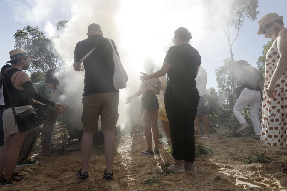 Members of the public participate in an Aboriginal smoking ceremony during Australia Day ceremonies in Sydney, Tuesday, Jan. 26, 2021. (AP Photo/Rick Rycroft)