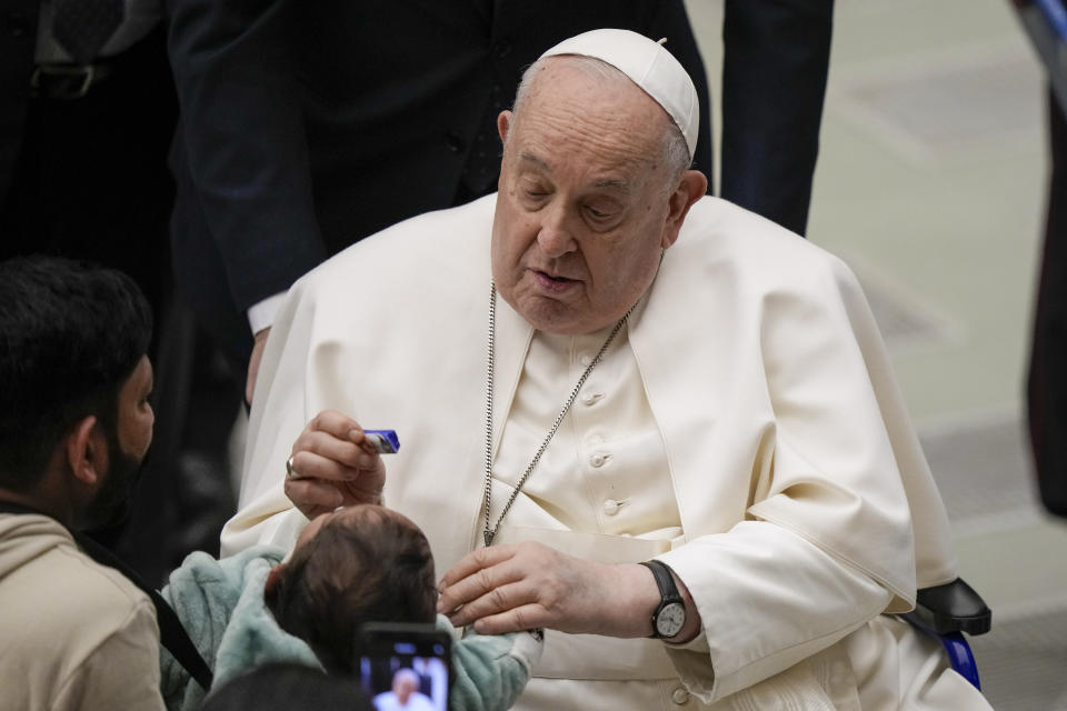 Pope Francis offers a child a sweet during his weekly general audience in the Pope Paul VI hall at the Vatican, Wednesday, Jan. 24, 2024. (AP Photo/Andrew Medichini)