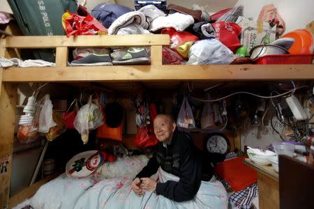 A man surnamed Zeng looks into the camera as he sits on his bed, in Guangfuli neighbourhood in Shanghai, China, April 18, 2016. REUTERS/Aly Song