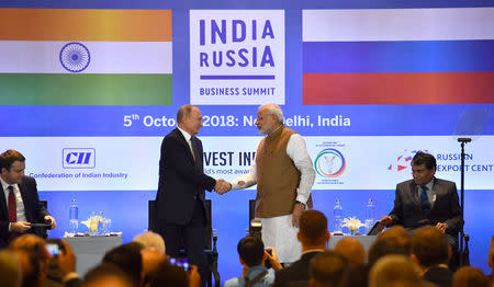 Russian President Vladimir Putin shakes hands with Prime Minister Narendra Modi during a session of the Russian-Indian business summit in New Delhi, October 5, 2018. Yuri Kadobnov/Pool via REUTERS