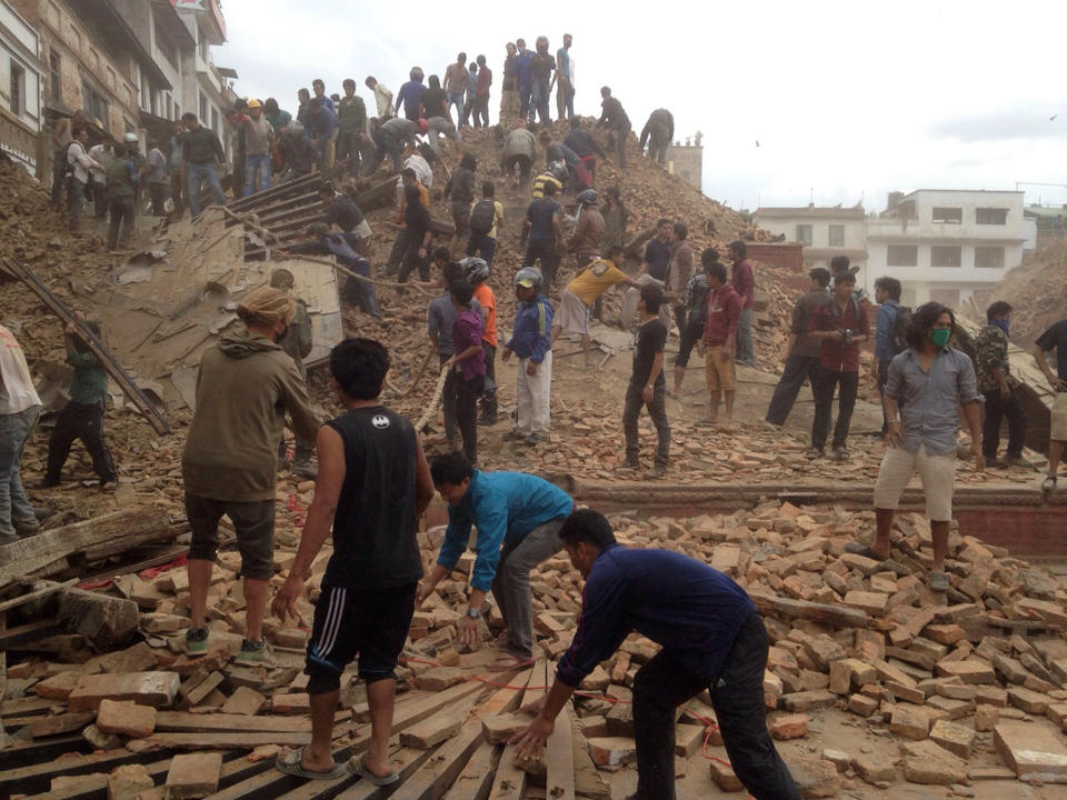 Volunteers help with rescue work at the site of a building that collapsed in Kathmandu, Nepal, April 25, 2015. (AP Photo/ Niranjan Shrestha)