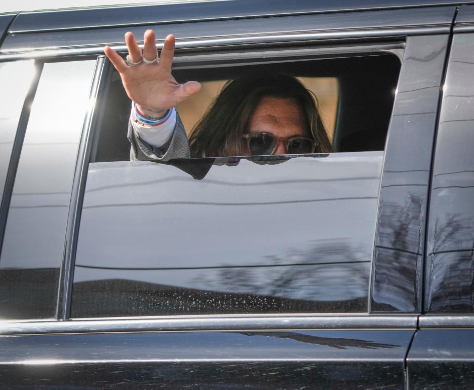 Johnny Depp departs and waves to fans in the streets near the Fairfax County Courthouse after the first day of a multi-million libel trial between Depp and ex-wife Amber Heard, April 11, 2022.