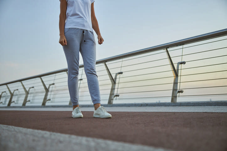 A woman wearing sweatpants and sneakers