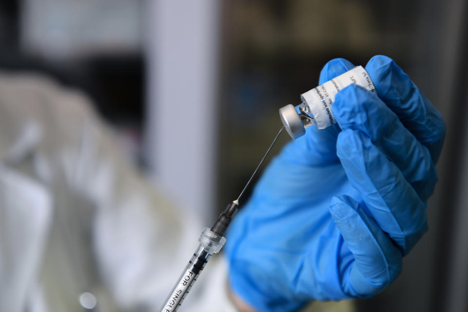 A medical professional handles a Covid-19 vaccine.