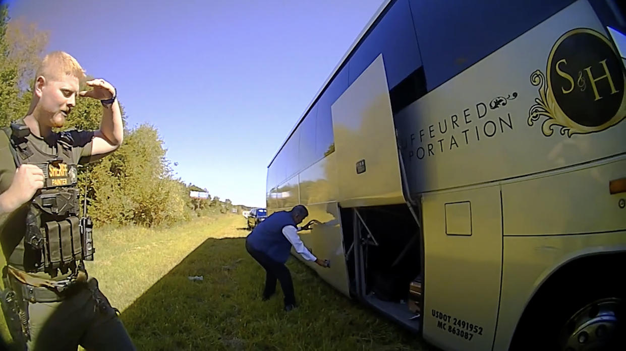 In this screenshot of a video released by Spartanburg County Sheriff’s Office, a bus driver opens the storage doors for law enforcement officers on Oct. 5, 2022, after officers in Spartanburg County, S.C., stopped a contract bus transporting students from Shaw University, an HBCU in Raleigh, N.C., to a conference in Atlanta. (Spartanburg County Sheriff’s Office via AP)