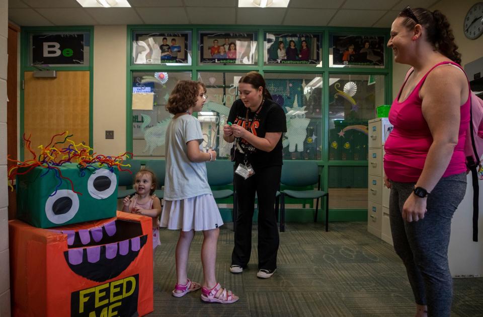 From left to right: Paisley Fox, Charlie Fox, Leah Thomas and Sarah Fox stand inside Charlie's school's office after school in Lapeer on Tuesday, Oct. 3, 2023. Charlie, who is autistic, was left on a school bus for over an hour before she was found. Thomas is Charlie's paraprofessional.