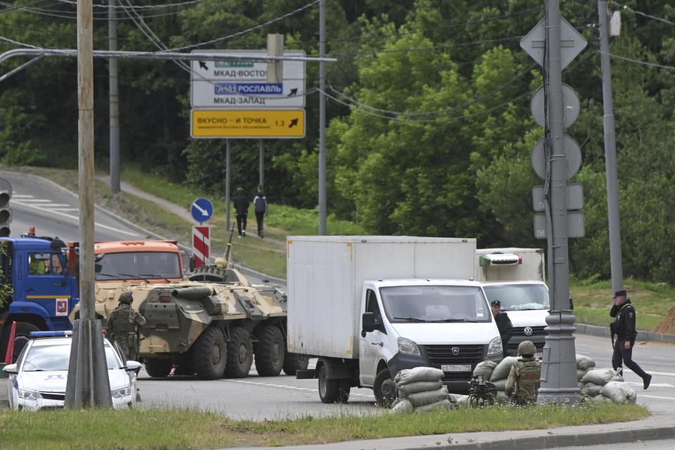 FILE - Russian army servicemen, and police officers guard the highway at the entrance to Moscow, Russia, Saturday, June 24, 2023. A week after the mutiny raised the most daunting challenge to President Vladimir Putin’s rule in over two decades, key details about the uprising remain shrouded in mystery. (AP Photo, File)