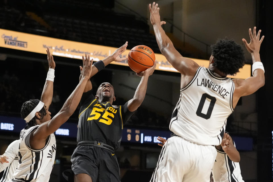 Missouri guard Sean East II (55) shoots the ball over Vanderbilt guard Ezra Manjon, left, and guard Tyrin Lawrence (0) during the first half of an NCAA college basketball game Saturday, Feb. 3, 2024, in Nashville, Tenn. (AP Photo/George Walker IV)