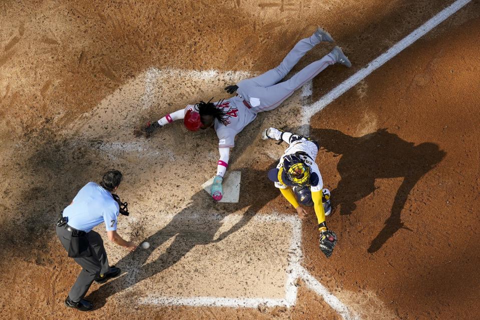 Elly De La Cruz of the Cincinnati Reds steals home with Milwaukee Brewers catcher William Contreras covering during the seventh inning of a baseball game Saturday, July 8, 2023, in Milwaukee. / Credit: Morry Gash / AP