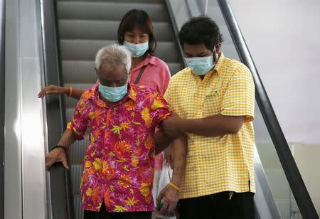 People wearing masks to prevent contracting Middle East Respiratory Syndrome (MERS) ride on an escalator at the Bamrasnaradura Infectious Diseases Institute in Nonthaburi province, on the outskirts of Bangkok, Thailand, June 19, 2015. REUTERS/Chaiwat Subprasom
