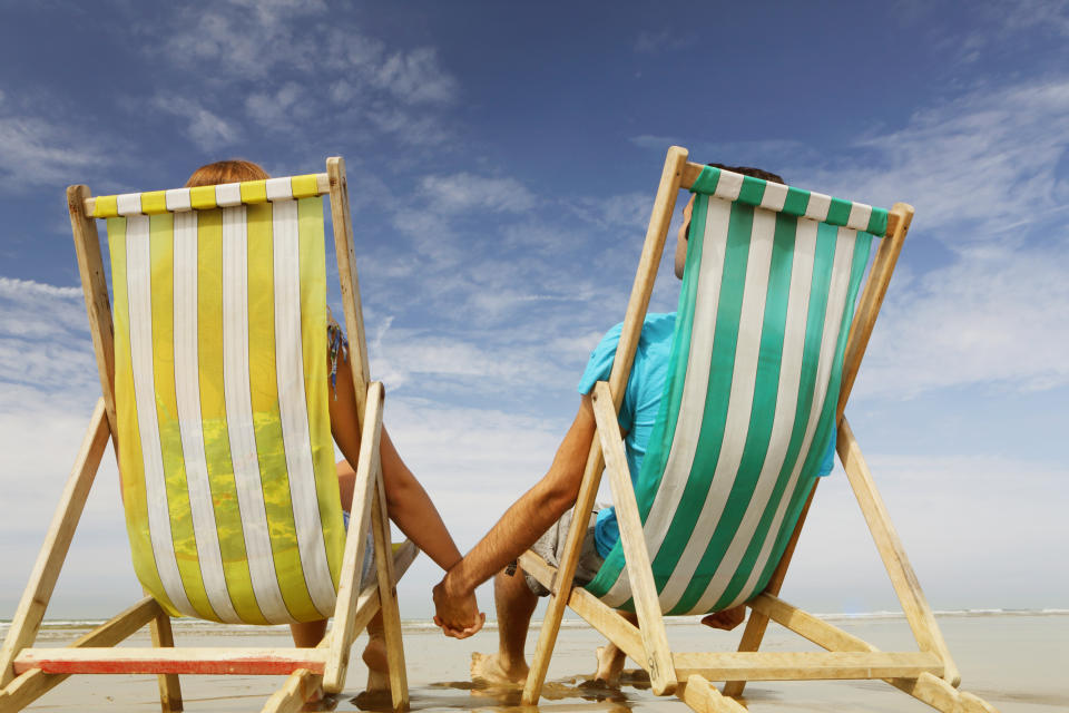 Man and woman on beach in deckchairs