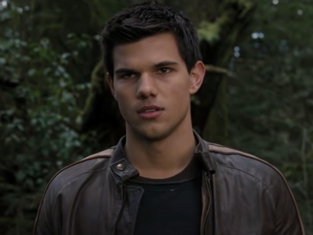 Jacob Black standing in forest in brown leather jacket in Breaking Dawn