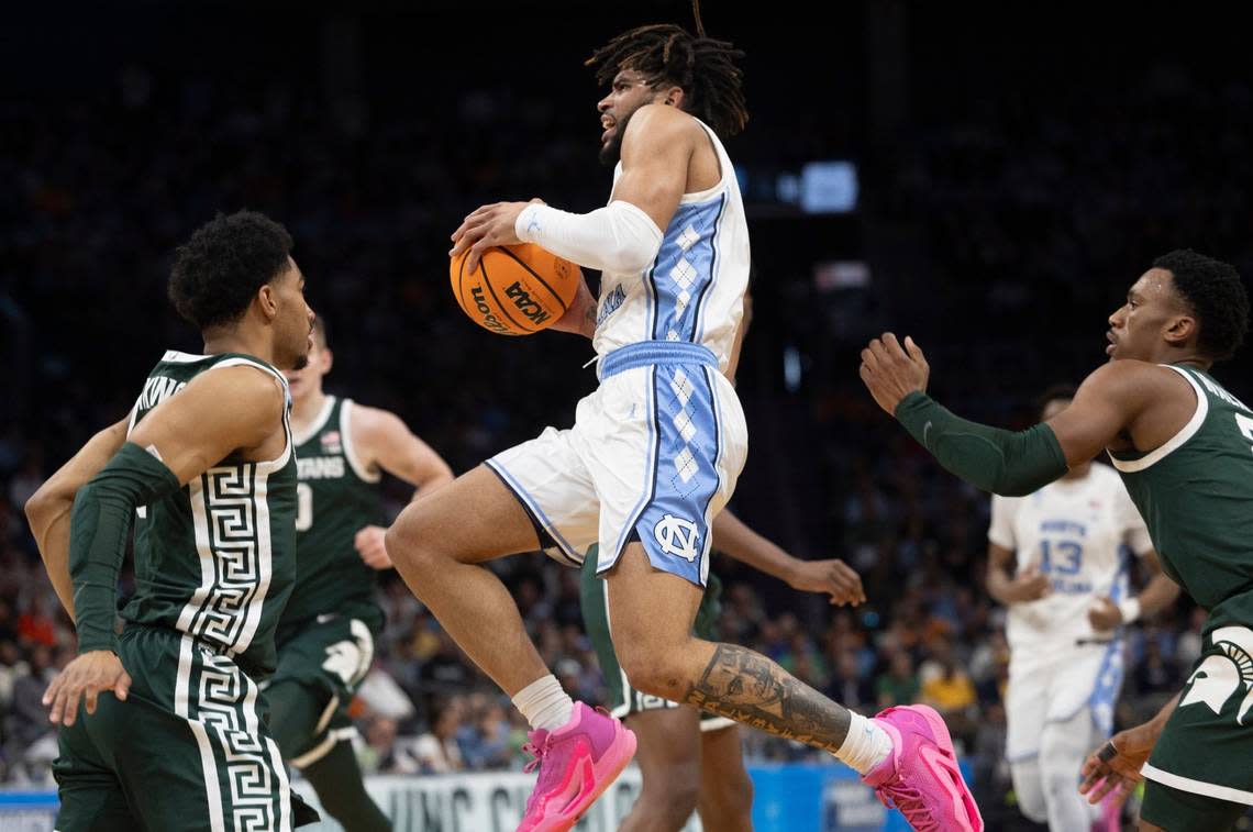 North Carolina’s R.J. Davis (4) drives to the basket against Michigan State’s Jaden Akins (3) and Tyson Walker (2) during the first half on Saturday, March 23, 2024, during the second round of the NCAA Tournament at Spectrum Center in Charlotte, N.C.