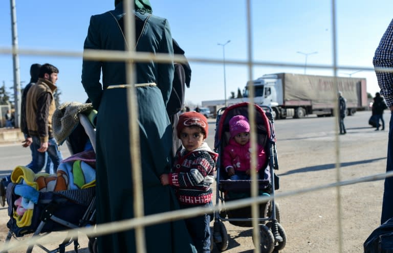 Syrian migrants wait in front of Turkey's Oncupinar crossing gate on February 9, 2016 in order to return to Syria