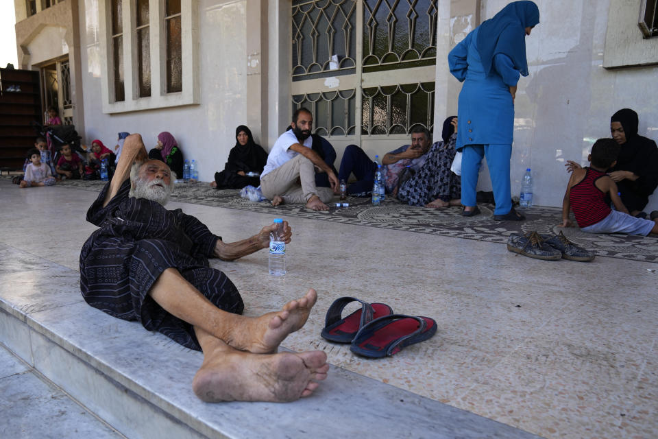 Palestinian residents who fled their home to a mosque, sit on the ground after clashes that erupted between members of the Palestinian Fatah group and Islamist militants in the Palestinian refugee camp of Ein el-Hilweh near the southern port city of Sidon, Lebanon, Sunday, Sept. 10, 2023. Islamist factions in Lebanon's largest Palestinian refugee camp said Sunday they will abide by a cease-fire after three days of clashes killed at least five people and left hundreds of families displaced. (AP Photo/Bilal Hussein)