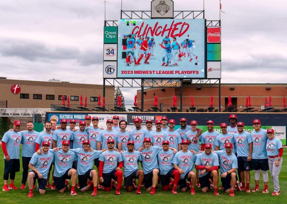 The Peoria Chiefs celebrate on the field with "playoff bound" shirts after clinching a spot in the 2023 Midwest League playoffs. They'll take on Cedar Rapids in the first round next week.