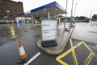A closed petrol station in Manchester, England, Tuesday, Sept. 28, 2021. Long lines of vehicles have formed at many gas stations around Britain since Friday, causing spillover traffic jams on busy roads. (AP Photo/Jon Super)