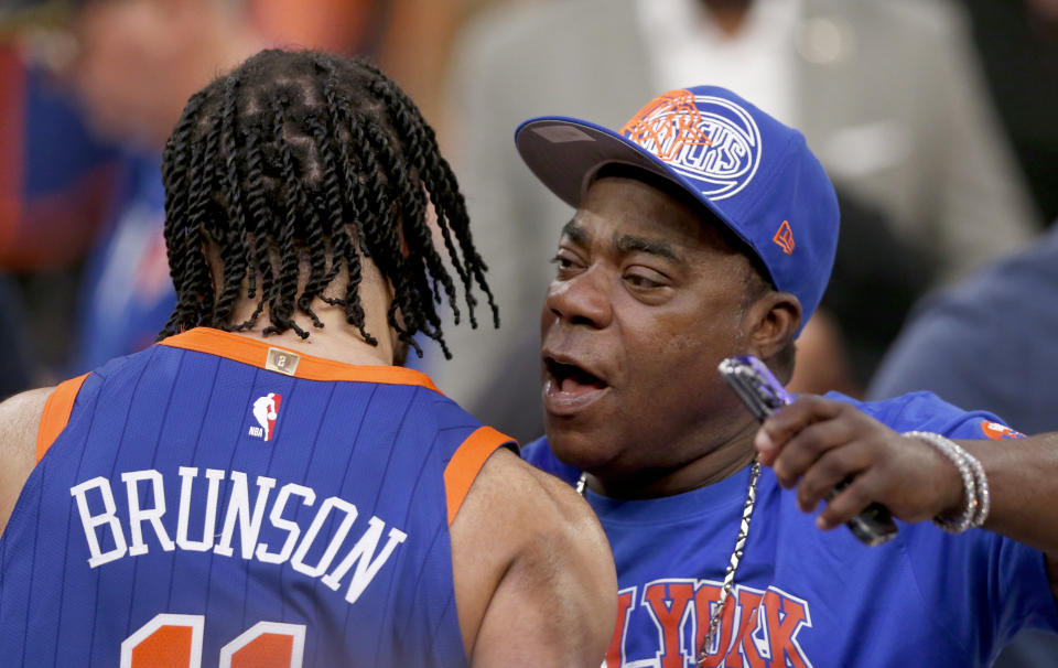 New York Knicks guard Jalen Brunson, left, hugs actor Tracy Morgan after the Knicks beat the Chicago Bulls in overtime in an NBA basketball game Sunday, April 14, 2024, in New York. (AP Photo/John Munson)