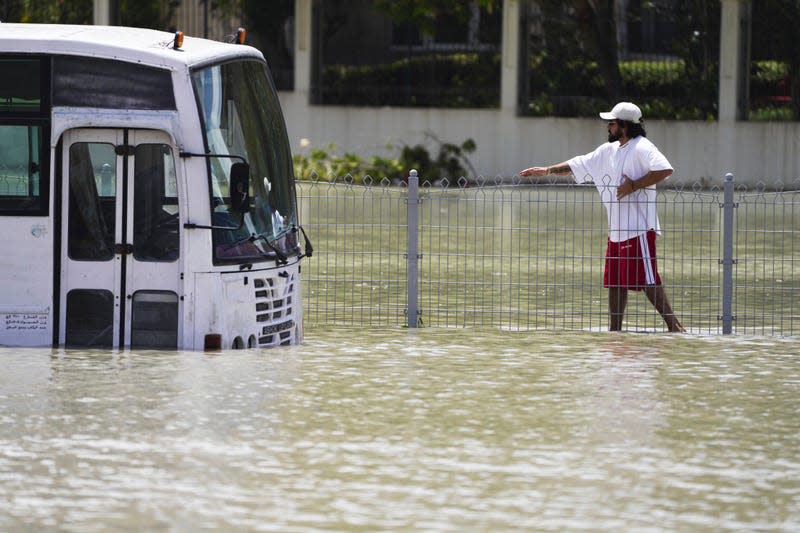 A man walks through floodwater in Dubai, United Arab Emirates, Wednesday, April 17, 2024. - Photo: Jon Gambrell (AP)