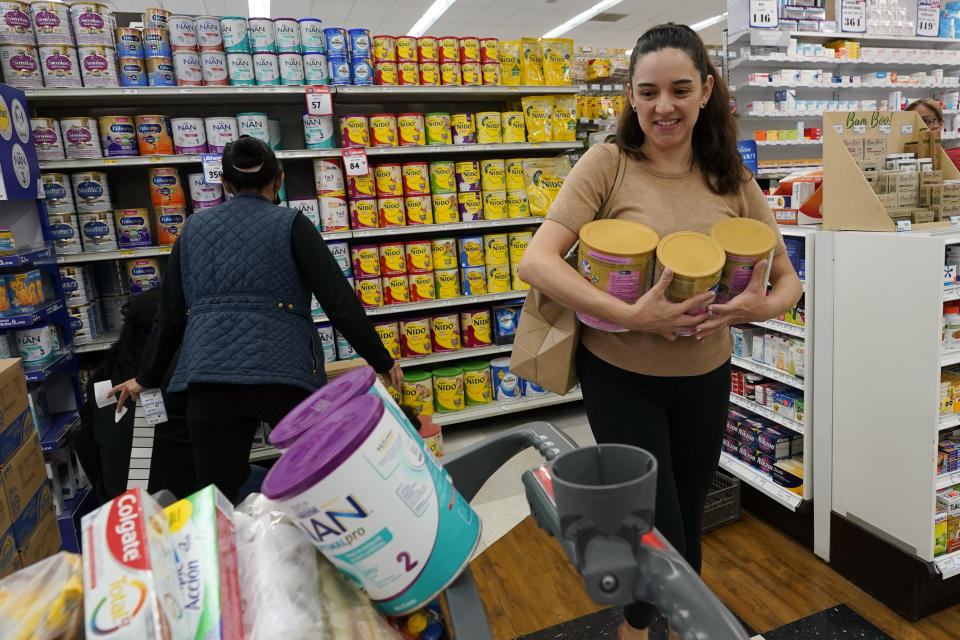 Michelle Saenz of Santee, Calif. buys baby formula at a grocery story across the border, Tuesday, May 24, 2022, in Tijuana, Mexico. As the baby formula shortage continues in the United States, some parents are opting to cross the border into Mexico, where the shelves are still stocked with options to feed their babies. (AP Photo/Gregory Bull)