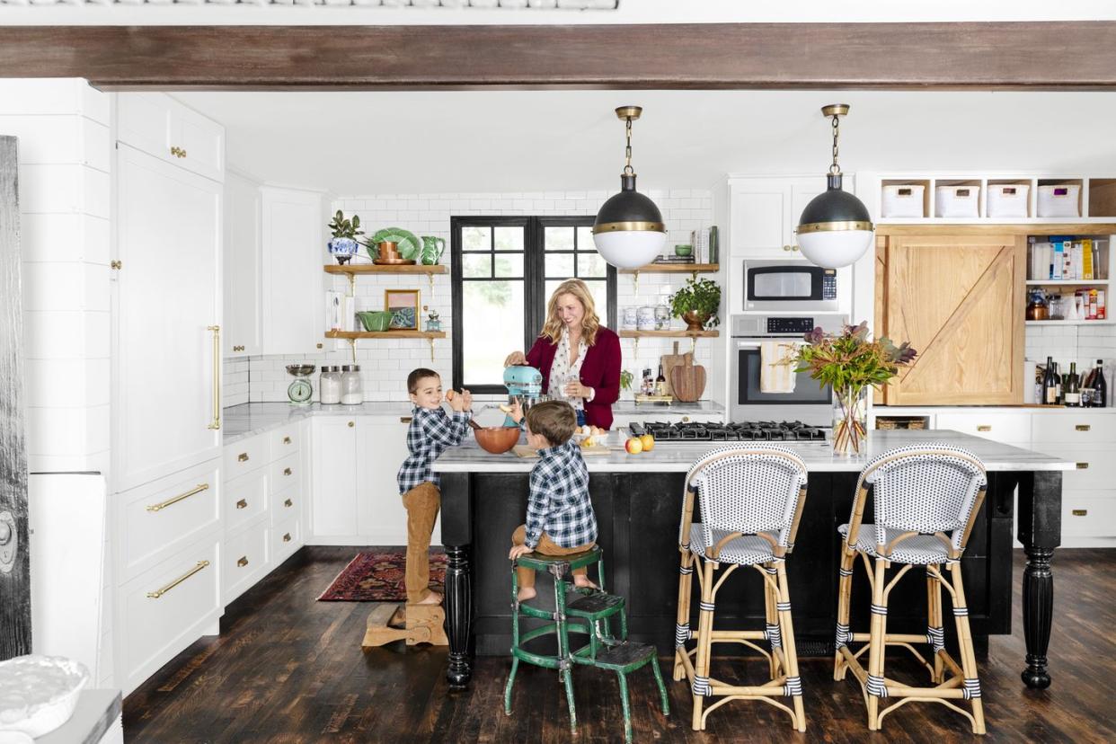 a mom and two boys in matching plaid shirts make cookies at a kitchen island