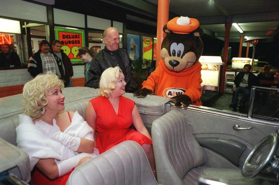 Look alike Marilyn Monroes’ Kristi Posey (left) and Lindsay Horton greet the A&W Bear while they sit in Weldon Smith’s (directly behind Horton) 1941 Ford at the A&W Drive-In at 14th & G streets in Modesto Friday evening. The A&W Drive-In celebrated the “last cruise of the millenium” Friday with vintage cars, 50’s music played by a Disc Jockey, and an Elvis /Marilyn Monroe look alike contest.