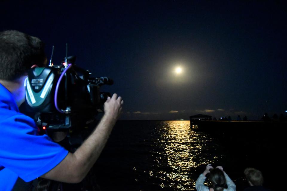 A man captures the launch of SpaceX's Falcon 9 rocket.