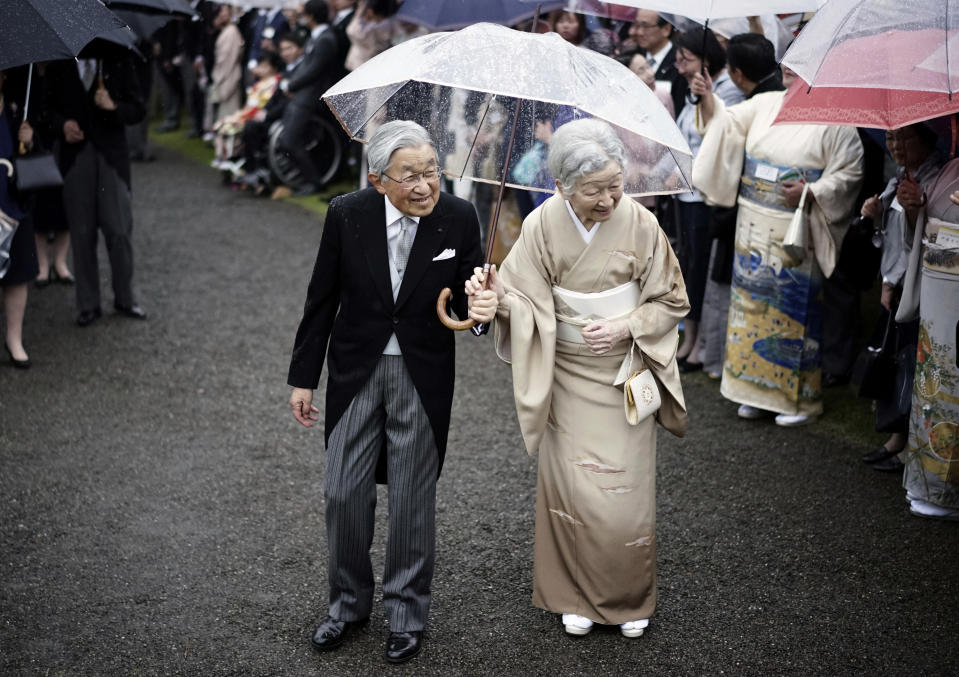 FILE - In this Nov. 9, 2018, file photo, Japan's Emperor Akihito, left, and Empress Michiko, right, greet the guests during the autumn garden party at the Akasaka Palace imperial garden in Tokyo. Akihito abdicated in 2019 at the age of 85, citing age and declining health in his decision to hand over the throne to his son Emperor Naruhito. It was Japan's first abdication in two centuries. (AP Photo/Eugene Hoshiko, File)